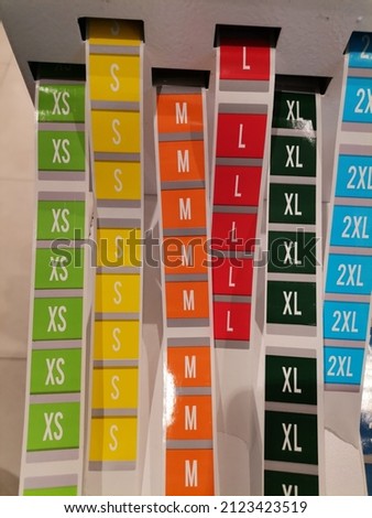 Strips in different colors with label sizes, which are placed on clothes in stores to make it easier for customers to find the right size, for sizes XS, S, M, L, XL, 2XL.
