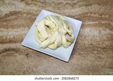 Strips Of Oaxaca Cheese On A White Plate.