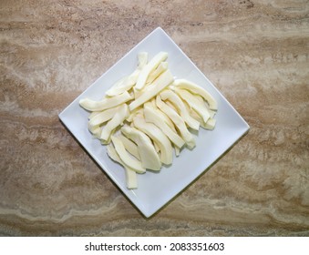 Strips Of Oaxaca Cheese On A White Plate For Making Tamales.