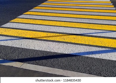 Strips of white and yellow pedestrian crossing on a Sunny day