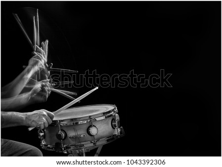 Stroboscopic B&W action photo of a drummer's drumsticks hitting and rebounding on a snare drum.