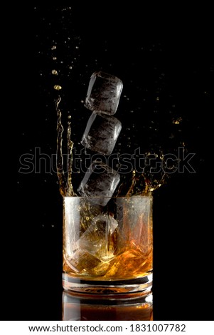 Stroboscopic effect. Whiskey splash with ice cube.