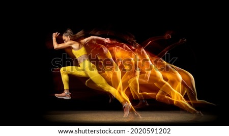 Stroboscopic effect. Young woman, female professional track athlete running isolated over black studio background in mixed neon lights. Concept of sport, healthy lifestyle, motion. Copy space for ad.