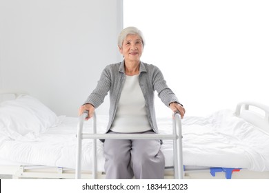 stroke patient learning to use walker in her home, Asian old female sitting on bed, she feeling happy in walk training time, rehabilitation process