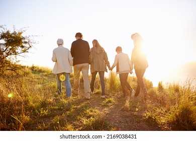 Strolling on a golden afternoon. Rearview shot of a multi-generational family walking together at sunset. - Powered by Shutterstock