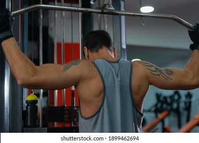 Strong 50 Year Old Man Exercising Lat Pushdown At The Cable Machine In A Fitness Club