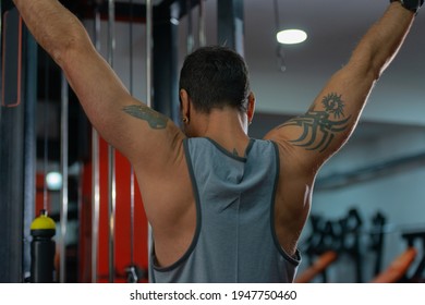 Strong 50 Year Old Man Exercising Lat Pushdown At The Cable Machine In A Fitness Club