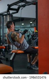 Strong 50 Year Old Man Exercising Lat Pushdown At The Cable Machine In A Fitness Club