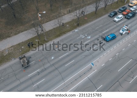Strong accident in the city. Top view of traffic jam. Traffic accidents on the road. The light vehicle overturned after the impact.