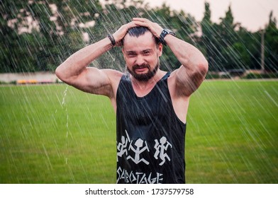 Strong and active guy in the rain at the stadium