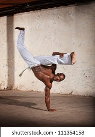 Strong African man demonstrating a Capoeria one armed kick