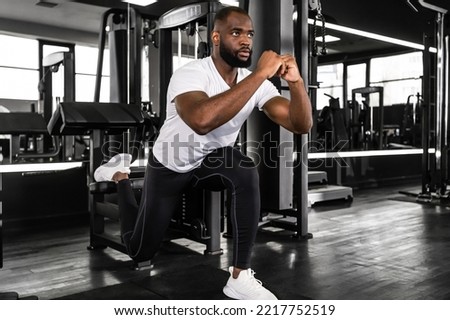 Strong african sportsman doing bulgarian lunges in a gym