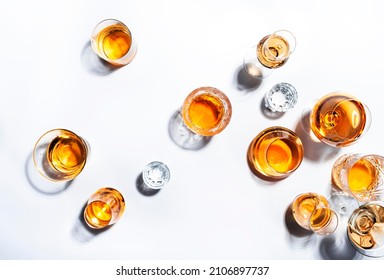 Strong alcoholic drinks, hard liquors, spirits and distillates in glasses: vodka, cognac, whiskey and other. White background. Hard light, copy space - Shutterstock ID 2106897737