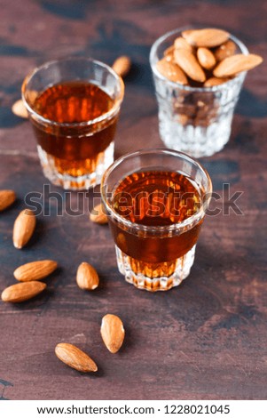 strong alcoholic Italian liqueur "Amaretto" with almonds nuts on a wooden table, party at the bar,  menu for the bar, selective focus