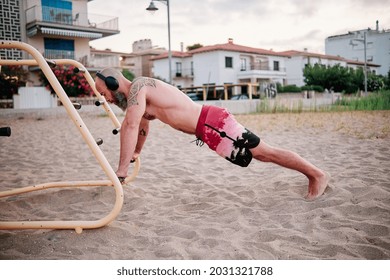 Strong Athlete Man Doing Exercises In Calisthenics Park On The Beach.