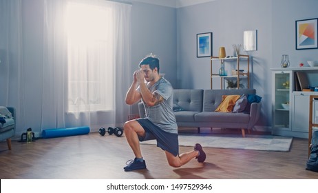 Strong Athletic Fit Man in T-shirt and Shorts is Doing Forward Lunge Exercises at Home in His Spacious and Bright Apartment with Minimalistic Interior.