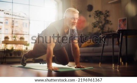 Strong Athletic Fit Middle Aged Man Doing Mountain Climber Exercises During Morning Workout at Home in Sunny Apartment. Healthy Lifestyle, Fitness, Recreation, Wellbeing and Retirement.