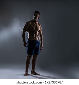 Strong Athletic Man Fitness Model Torso Showing Six Pack Abs. Isolated On Dark Background With Copy-space