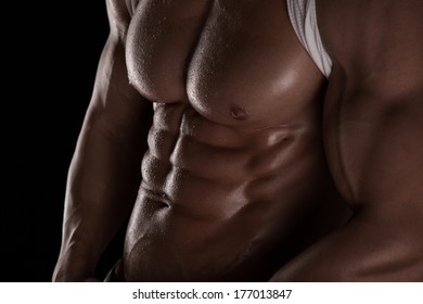 Strong Athletic Man Fitness Model Torso Showing Six Pack Abs. Isolated On Black Background