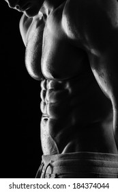 Strong Athletic Man Fitness Model Torso Showing Six Pack Abs. Isolated On Black Background