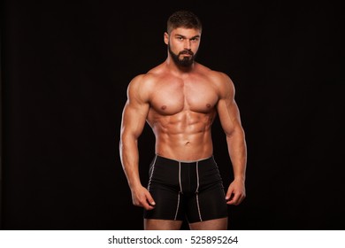 Strong Athletic Man Fitness Model Torso Showing Six Pack Abs. Isolated On Black Background With Copyspace