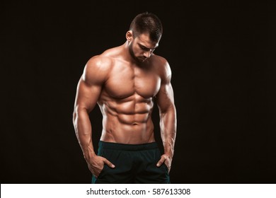 Strong Athletic Man - Fitness Model showing his perfect back isolated on black background with copyspace