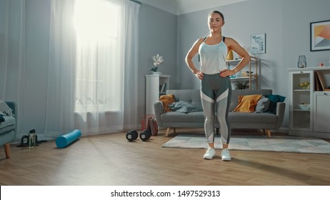 Strong and Beautiful Athletic Fitness Girl in Sportswear Prepeared for Forward Lunge Exercises in Her Bright and Spacious Apartment with Minimalistic Interior.
