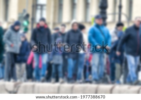 Strong blurred, crowds of anonymous people in metropolis. Masses of citizens in the spring on the street