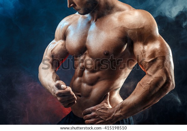 Strong bodybuilder man with perfect abs, shoulders, biceps, triceps, chest.