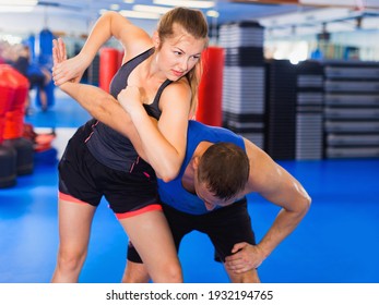 Strong Bold Cheerful Woman Is Training Captures With Man On The Self-defense Course In Gym.