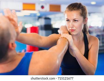 Strong Bold  Woman Is Training With Man On The Self-defense Course In Gym.