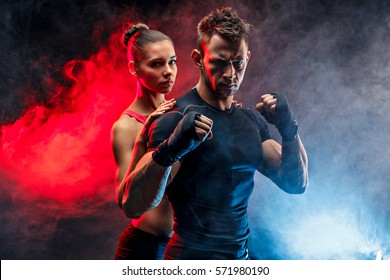 Strong boxer in stance with handwraps on his fists. With girlfriend standing behind him. - Powered by Shutterstock