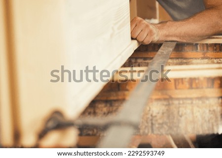 Strong carpenter's hands hold, guide, restrain, push, and move lumber while working with powerful cutting machines in his workshop. Image conveys strength, skill, and risk-taking expertise