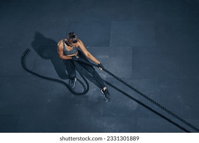 Strong caucasian woman pulling rope top view. Sporty woman in sportswear working out in gym. Strength and motivation. - Powered by Shutterstock