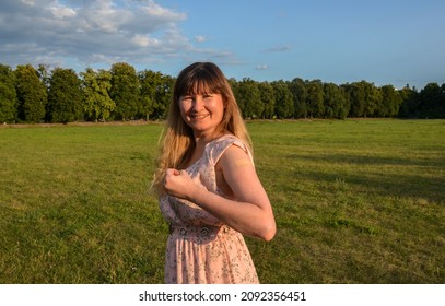 Strong Cheerful Vaccinated Woman Flexing Arm Muscle Showing With Adhesive Bandage After Vaccine Injection For Covid-19. Stay Strong And Protected During A Pandemic