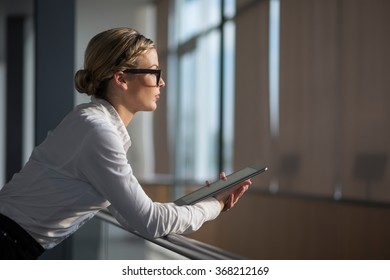 Strong, Confident, Business Woman Standing In An Office Building, Holding Tablet Computer