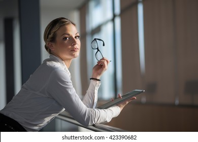 Strong, Confident, Business Woman Standing In An Office Building Hallway, Holding Tablet Computer