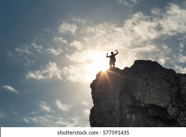 Strong Confident Man Standing On Top A Mountain. Success Life Goals And Overcoming Obstacles Concept.  