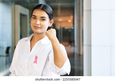 Strong and confident South Asian woman with pink ribbon, concept of love and care in breast cancer awareness day or month - Shutterstock ID 2255585047