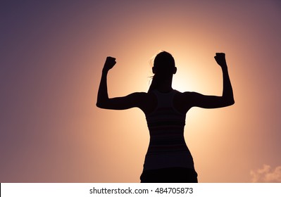 Strong and confident woman flexing her muscle. 