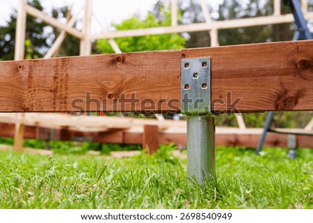 A strong deck foundation under construction with a ground screw and wood frame support. This stable base is ideal for outdoor projects and showcases effective building techniques.