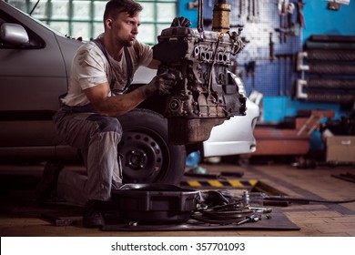 Strong Dirty Mechanic Pulling Out The Engine From Car