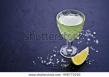 Strong drink on a dark background with salt and lime. Selective focus.