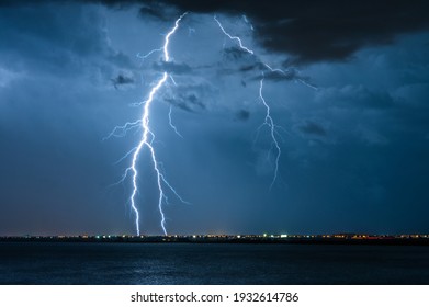Strong electrical storm with a multitude of lightning strikes the ocean.