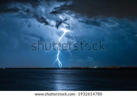 Strong electrical storm with a multitude of lightning strikes the ocean.