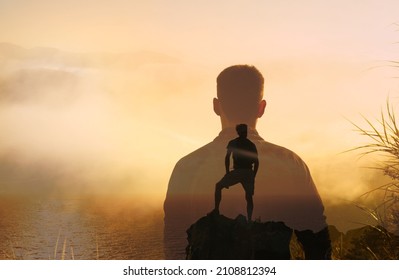 Strong fearless young man standing on a mountain. Thoughtful man looking out at the view. Dreaming and having a vision concept. 