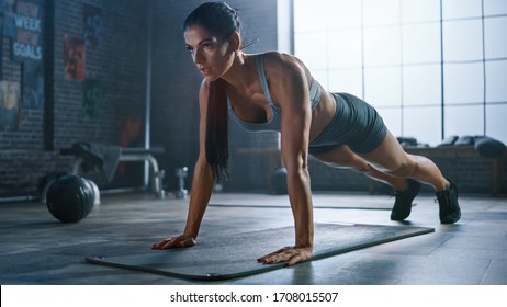 Strong and Fit Athletic Woman in Sport Top and Shorts is Doing Push Up Exercises in a Loft Style Industrial Gym with Motivational Posters. It's Part of Her  Fitness Training Workout. - Shutterstock ID 1708015507