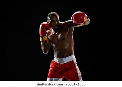 Strong and focused boxing athlete in motion, punching, fighting shirtless in boxing ring isolated on black background. Concept of professional sport, active lifestyle, body, strength - Powered by Shutterstock