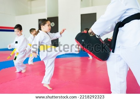 Strong girl kicking and practicing taekwondo sports with a karate trainer 