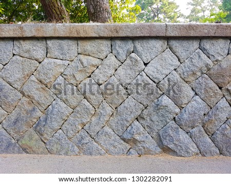 The strong granite stone wall that build on the sandy beach along coastline.